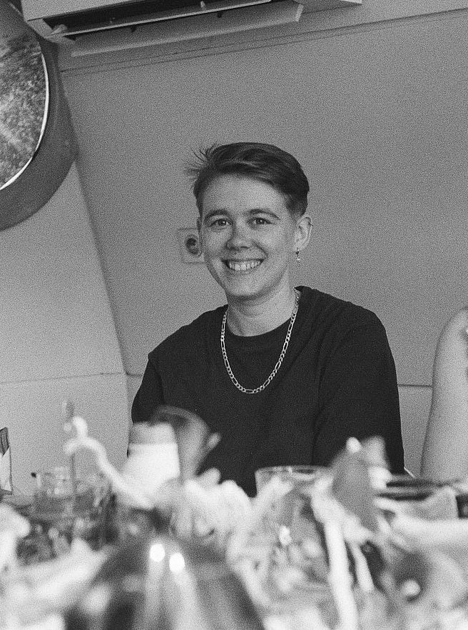 Fil smiling at the camera, seated at a table.
